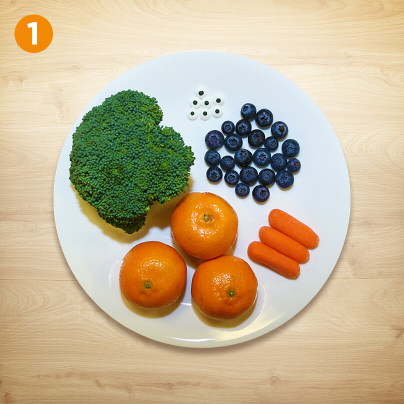Picture of broccoli, blueberries and oranges and carrots on a plate