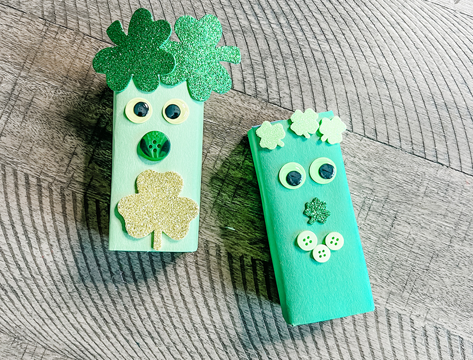 Two finished st patricks day creatures unique and decorated with googly eyes, stickers, green construction paper and more
