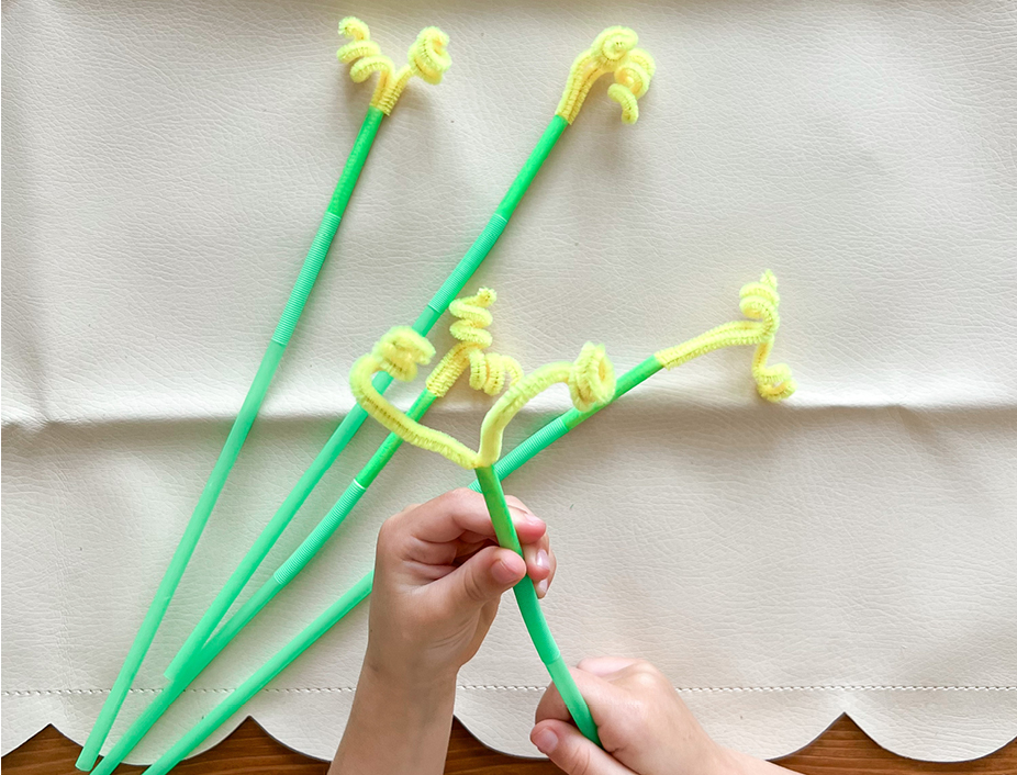yellow pipe cleaners fed through the green straw to creat a flower stem