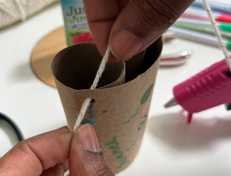 hole punching the binuculars/paper roll and putting a string through the hole punched hole