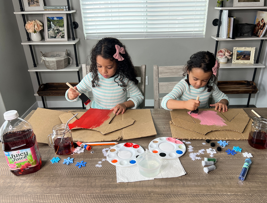 young children painting their cardboard cutout sweaters