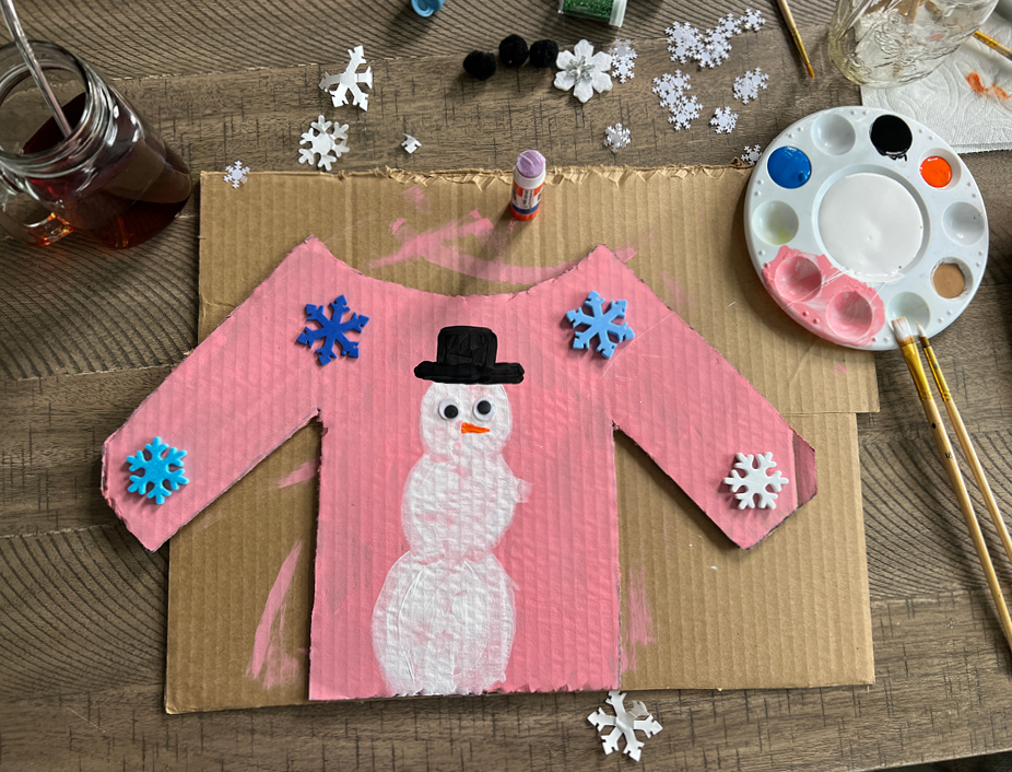 cardboard cutout sweater painted pink with a snowman
