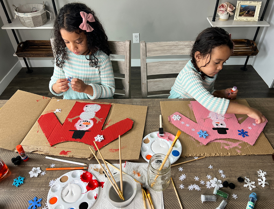 young children painting their cardboard cutout sweaters