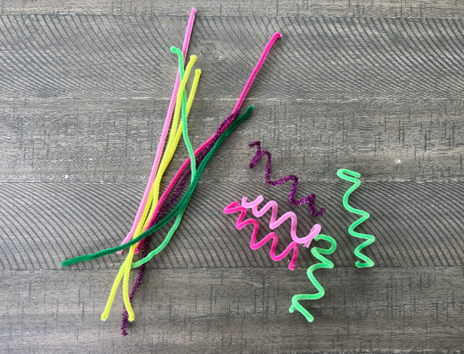 Creating beautiful hair for your sock puppet: Forming a spiral effect with a craft pipe cleaner wrapped around a finger.