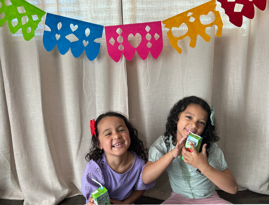 kids posing with their cinco de mayo banners drinking Juicy Juice